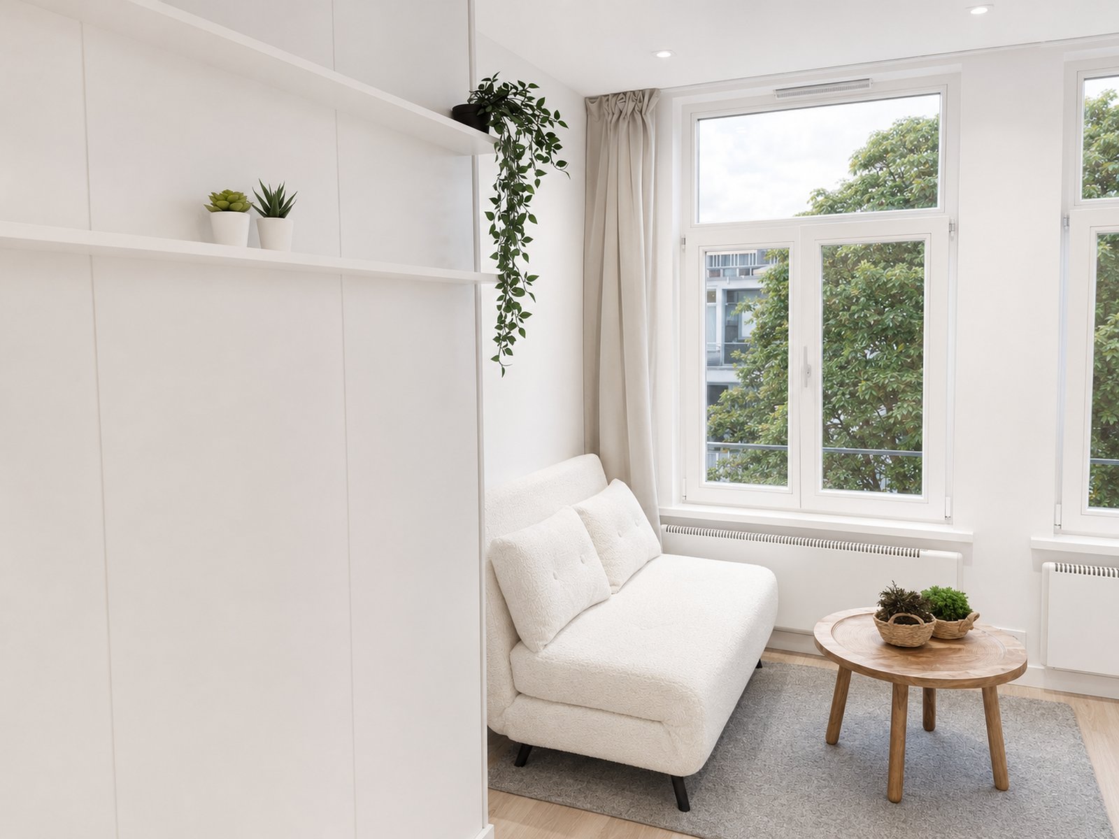 Living area in renovated studio apartment Oud-Zuid Amsterdam, with built-in Murphy bed wall, trailing plants on shelves, white boucle sofa and large windows with garden views - Ruimte interior design