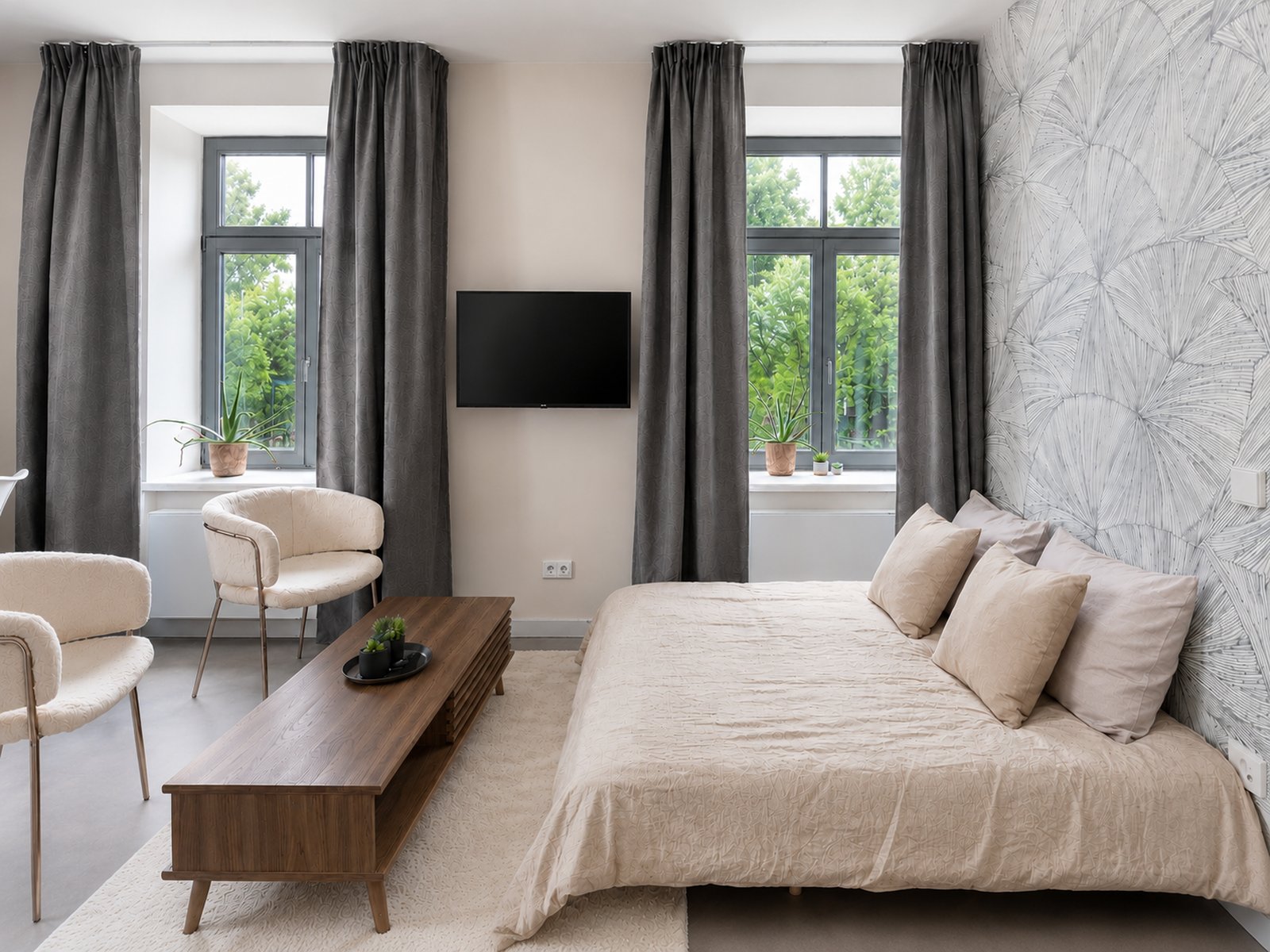Living room with sofa bed made up as a double bed, hand-drawn wallpaper by the family's autistic son, and swivel-arm TV, 39m² pied-à-terre Kipsala Riga — Ruimte interior design