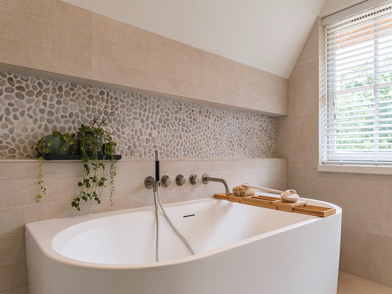 Freestanding bath with pebble stone niche, wall-mounted tap and bamboo tray, attic bathroom Garden House Huizen - Ruimte interior design