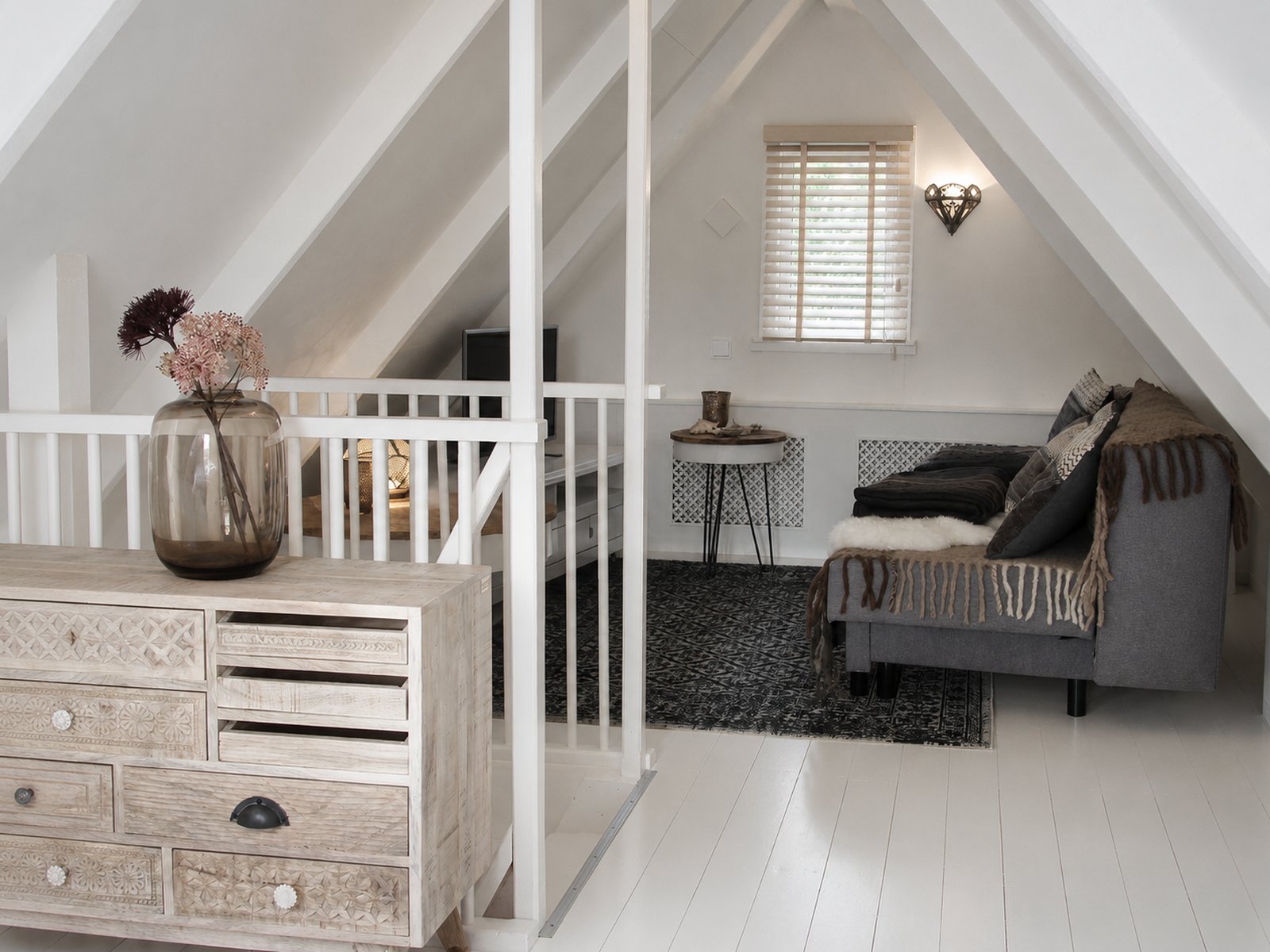 Attic landing sitting area with carved dresser and sofa, weekend house Schoorl - Ruimte interior design