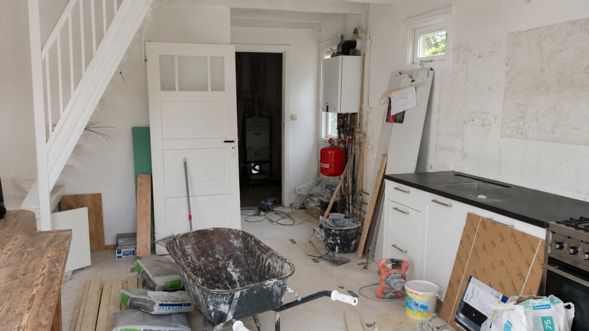 Ground floor of weekend house Schoorl mid-renovation, showing stripped walls, exposed plumbing and construction materials before full transformation - Ruimte
